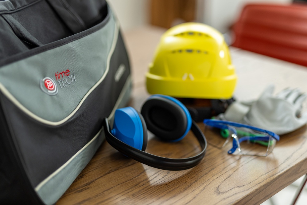 Dispositivi di protezione e borsa tecnica Time Tech su tavolo da lavoro
